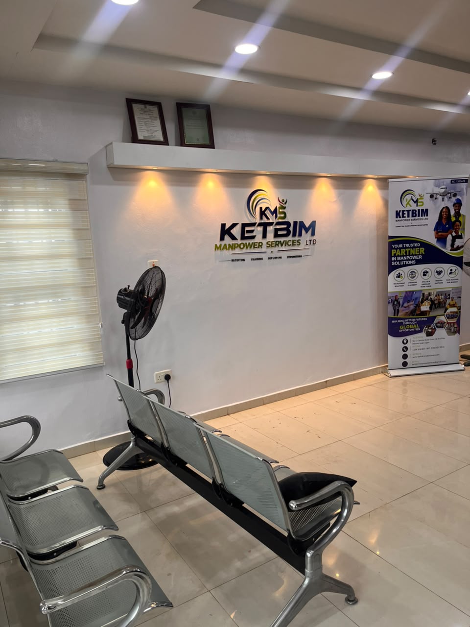 KETBIM reception area with the company logo on the wall, a roll-up banner and waiting-area seating