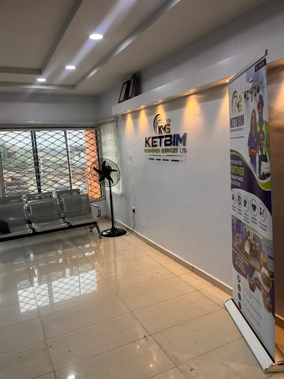 Reception waiting area with the KETBIM logo wall and roll-up banner